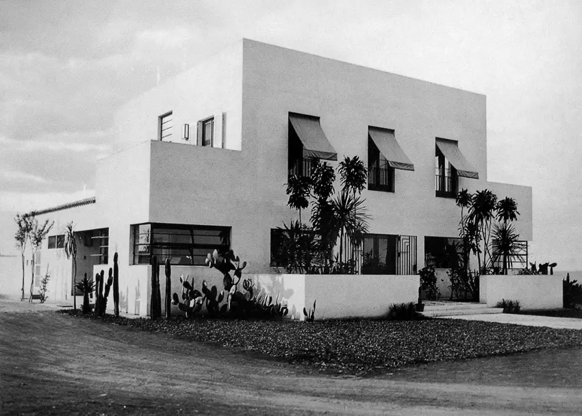 Edifício modernista com janelas grandes e plantas baixas.