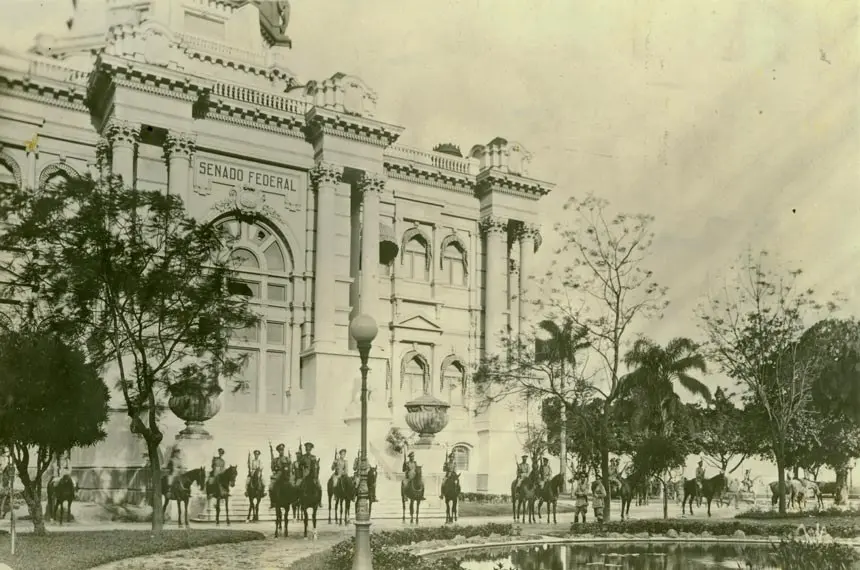 Edifício Senado Federal com soldados em cavalo e árvores.
