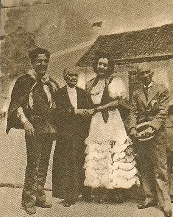 Quatro pessoas em trajes variados posam juntos em frente a um prédio.