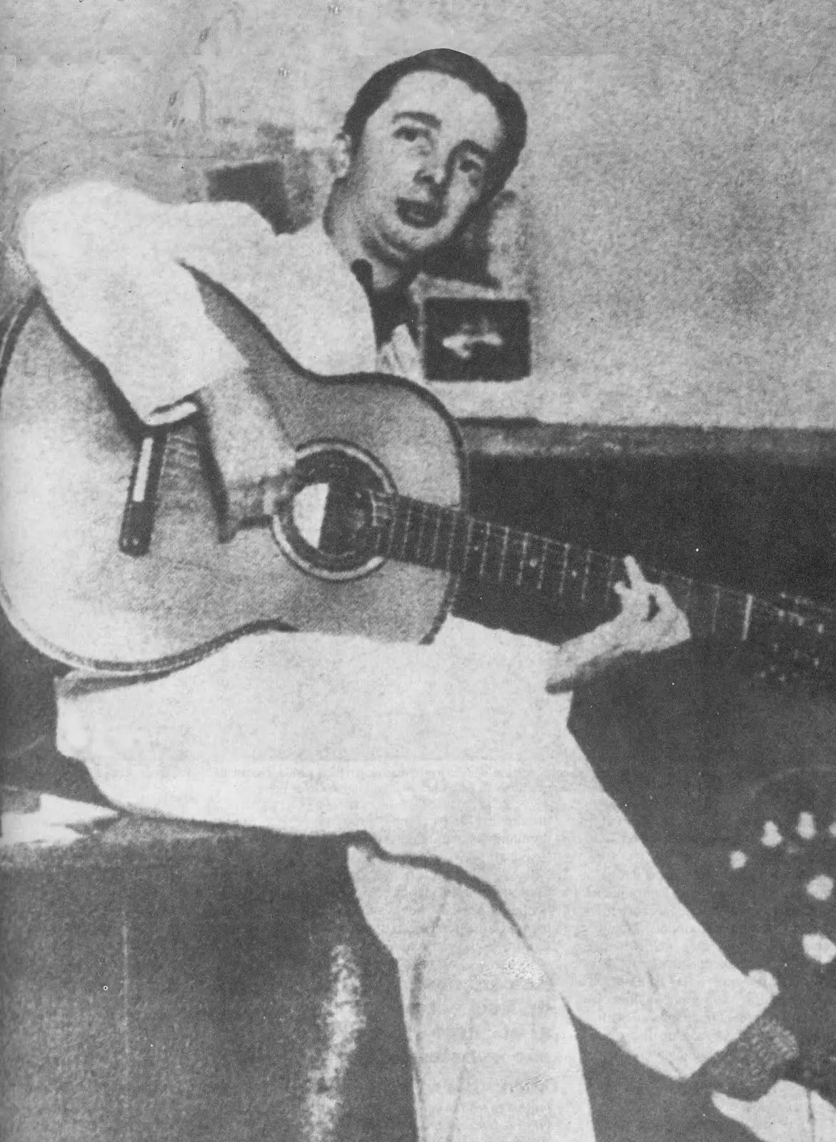 Pessoa tocando violão em preto e branco.