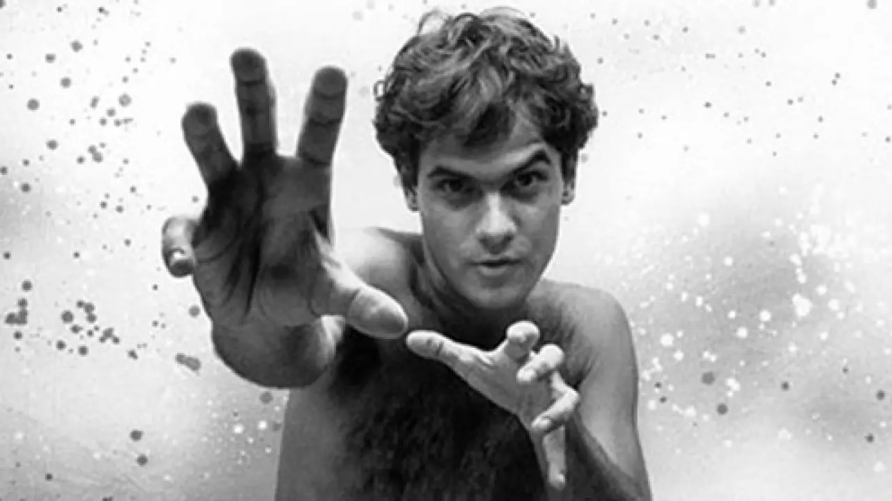 Homem nu, pose aberta, fundo claro.