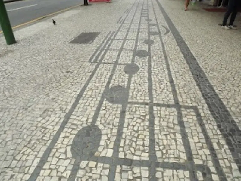 Piso de pedras portuguesas com padrão geométrico complexo.
