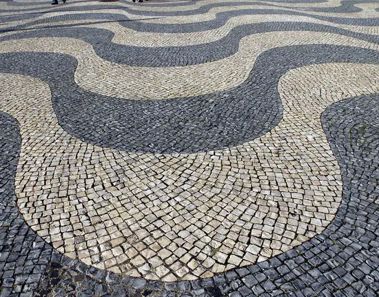 Piso de pedras em forma de ondas cinza-bege.