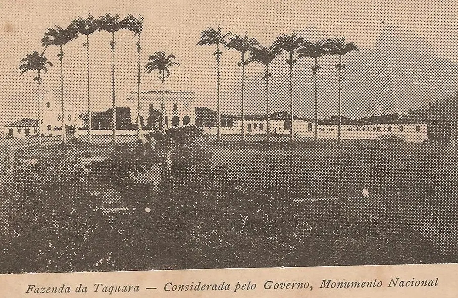 Fotografia antiga de fazenda com palmeiras e construções lineares.