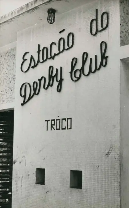 Fachada preto e branco com sinal "Estação do Derby Club" e "Trôco".
