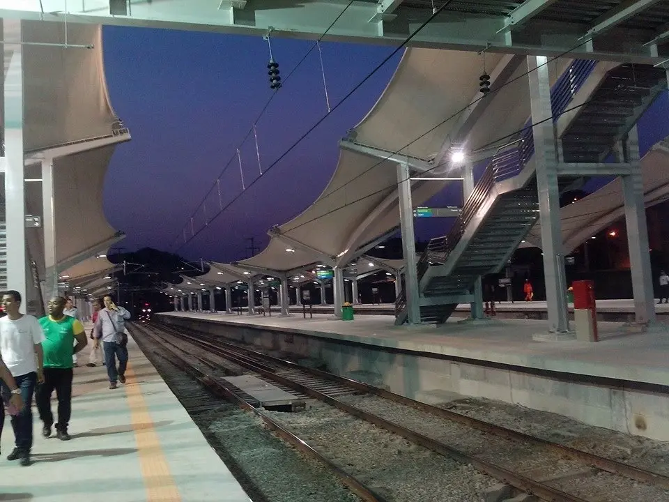 Estação ferroviária durante o crepúsculo, com trilhos e plataformas.