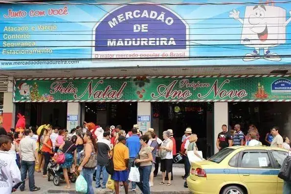 Mercado popular Mercadão de Madureira com pessoas caminhando.