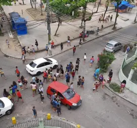 Rua em Taquara, Rio de Janeiro, com carros e pessoas caminhando.