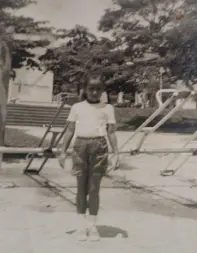 Menino caminhando em pátio com cadeiras de balanço.