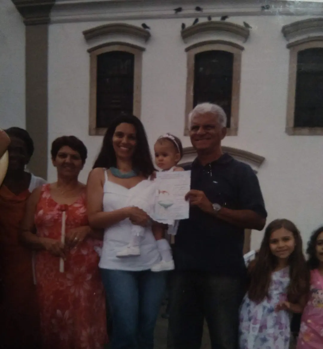 Família em frente a edifício com janelas arredondadas.