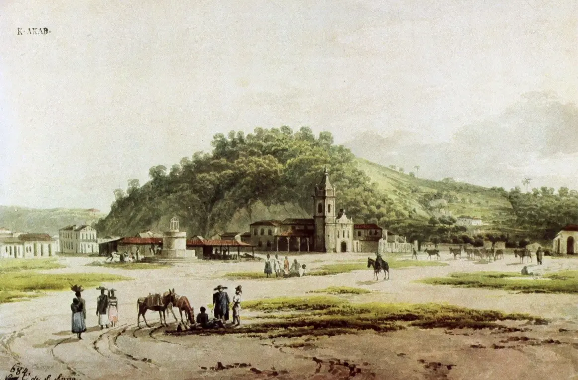 Cenário rural com casas simples, igreja e colina verde.