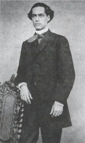 Homem em terno clássico posa com livro ornamental.