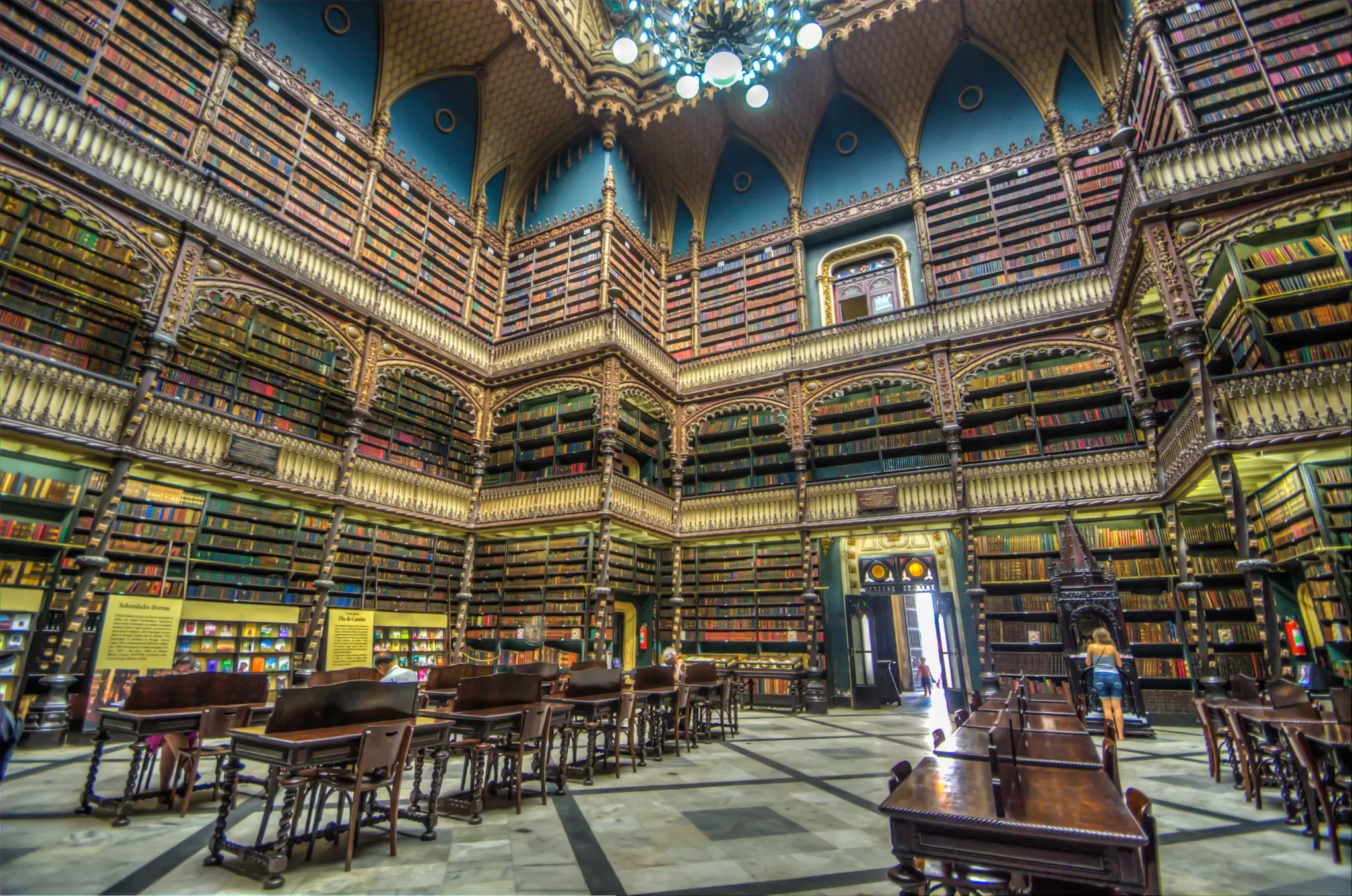 Interior de biblioteca com arquitetura histórica e mobiliário de leitura.