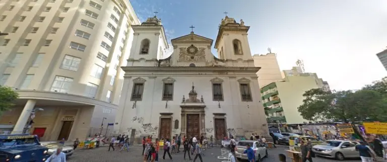 Igreja urbana com edifícios modernos ao lado.