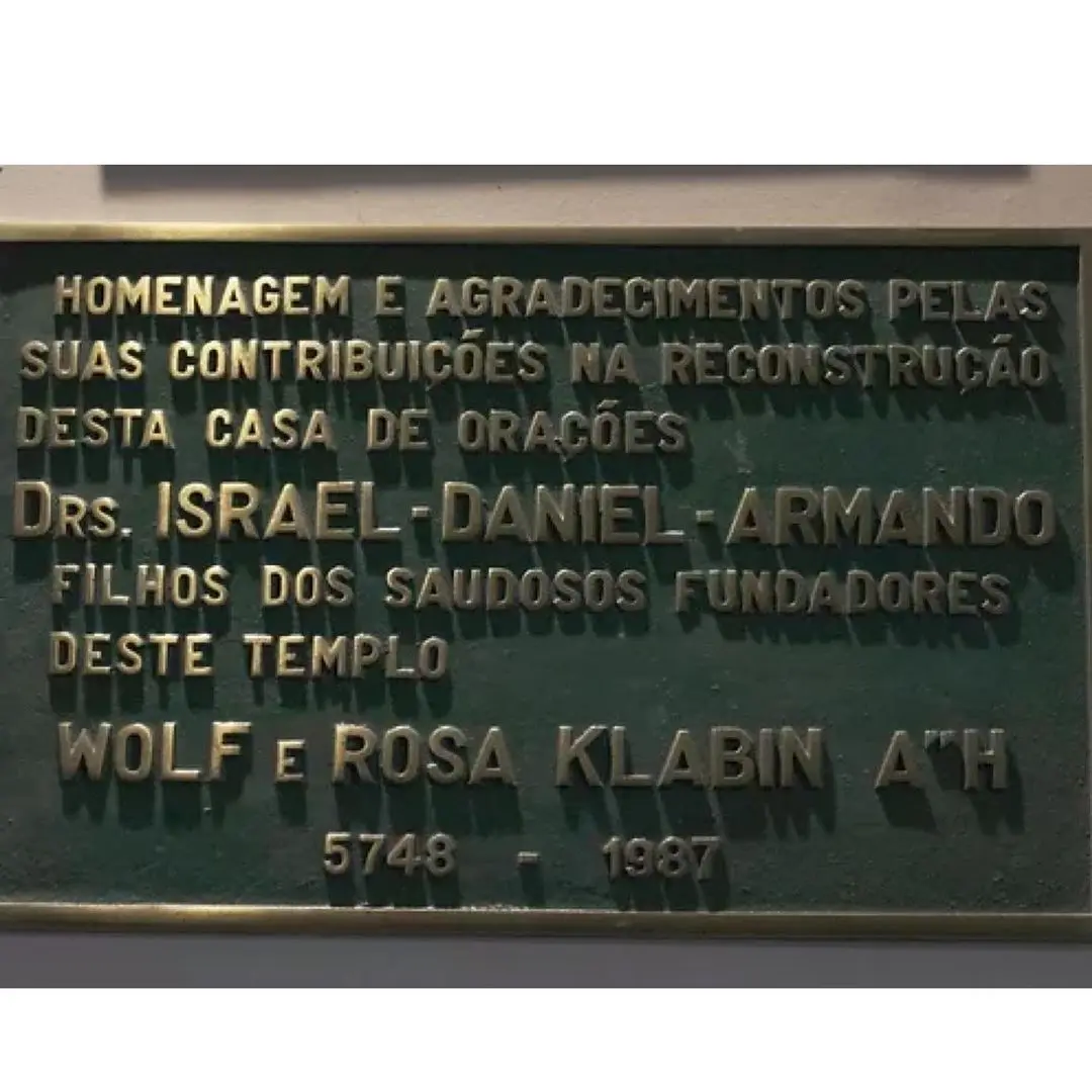 Placa verde com inscrições douradas homenageando contribuições para a reconstrução de um templo.