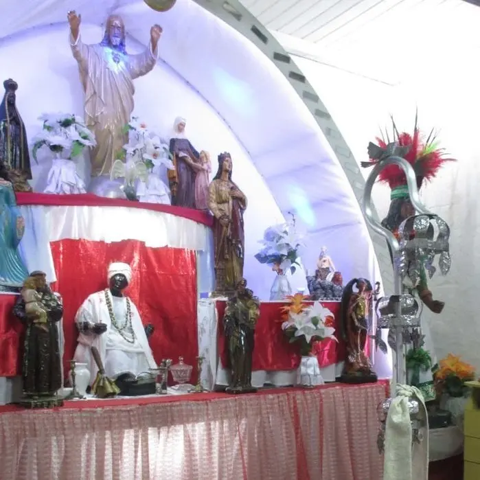 Altar de umbanda com estátuas femininas douradas e objetos religiosos.