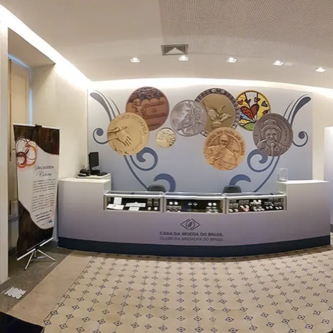 Interior de museu com parede dourada e azulejos geométricos.