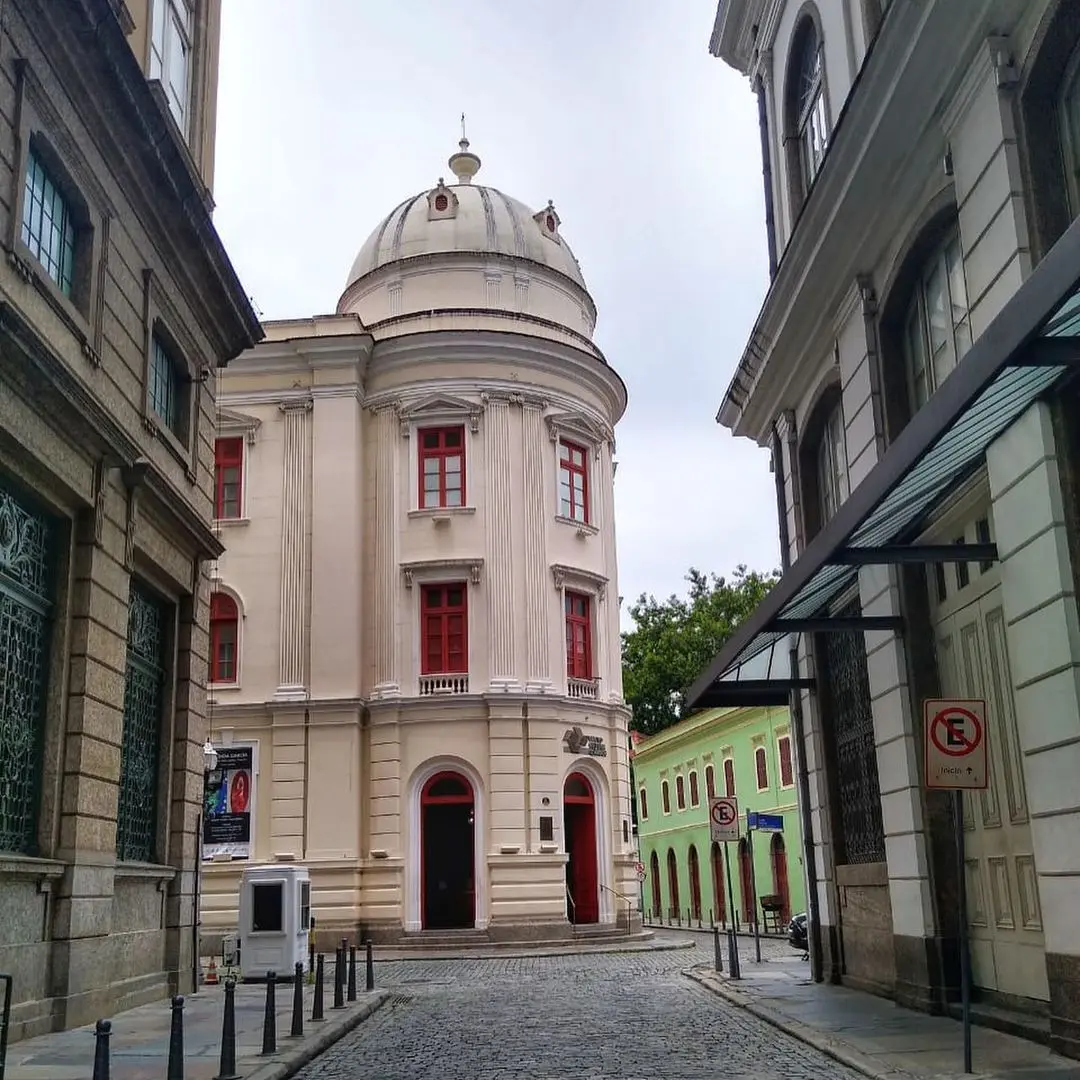 Prédio histórico com cúpula branca e fachada clara em centro cultural.