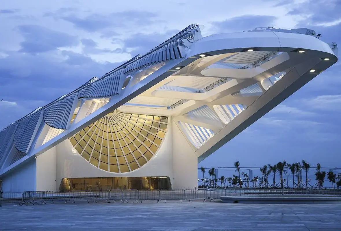 Edifício moderno com cúpula iluminada e estruturas dinâmicas.