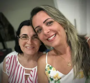 Duas mulheres sorridentes em um ambiente interno.