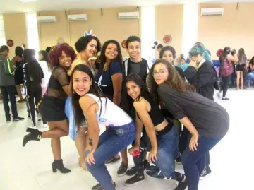 Grupo de pessoas sorrindo em sala de dança ou aula.