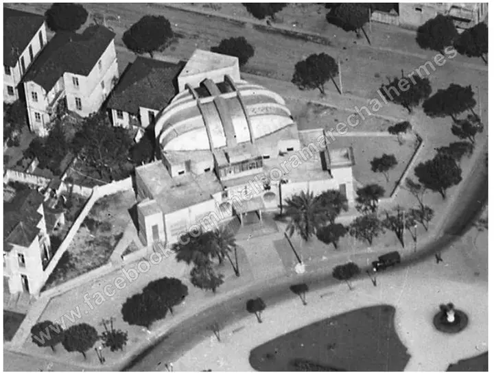 Edifício com cúpula, casas e árvores em preto e branco.