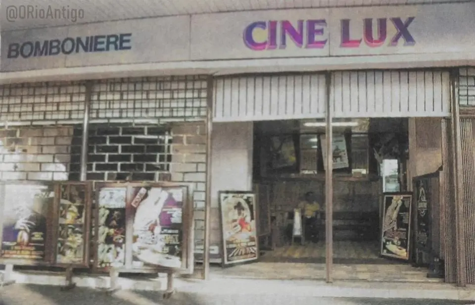 Fachada cinza do Cine Lux com loja de bomboniere à esquerda.