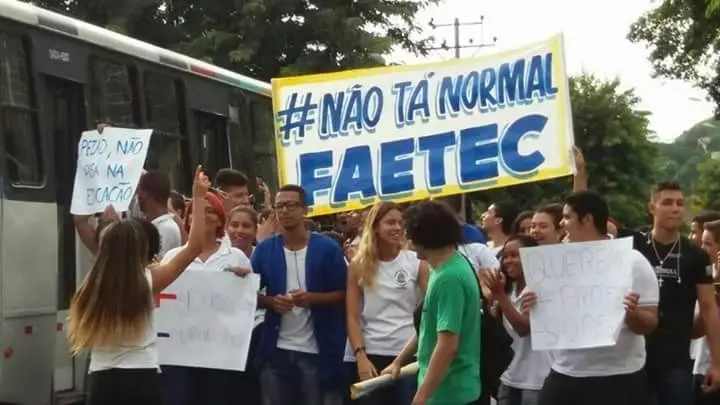 Manifestação com ônibus e cartazes amarelos.
