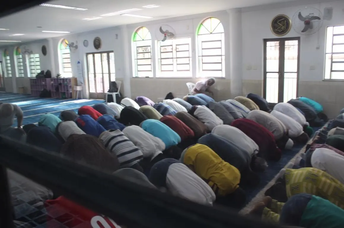 Mesquita com orantes e vitrais coloridos.