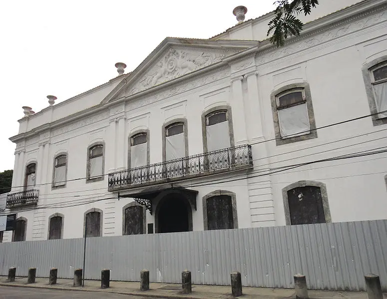 Edifício clássico com fachada detalhada e janelas pretas.