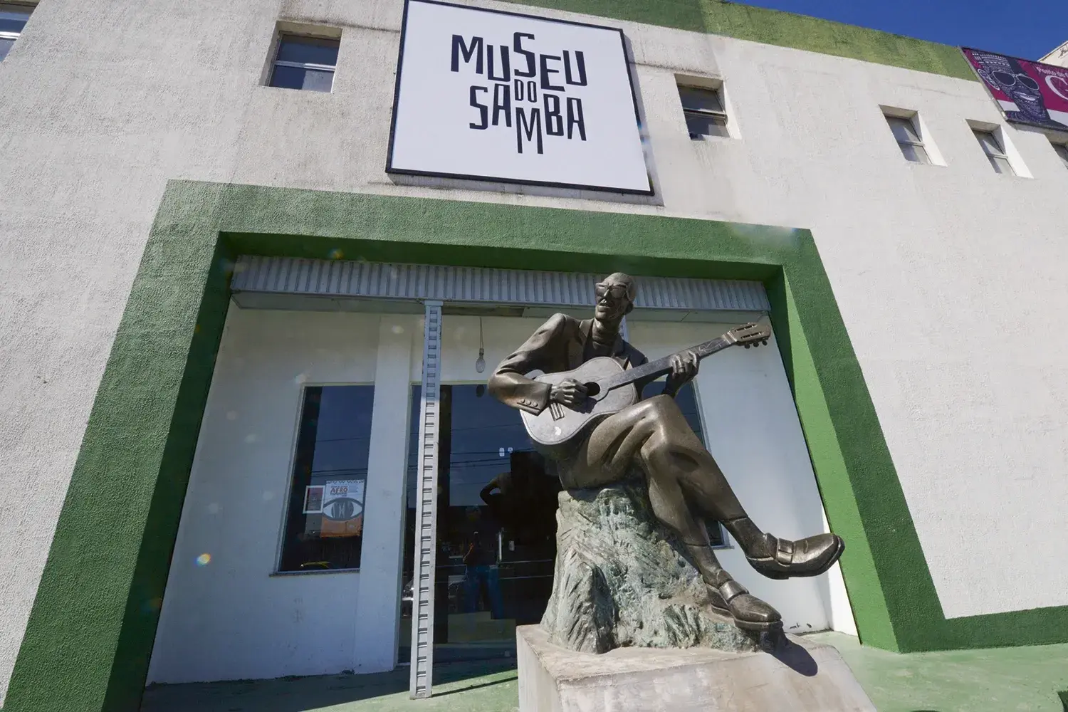 Fachada do Museu do Samba com estátua de bronze tocando violão.