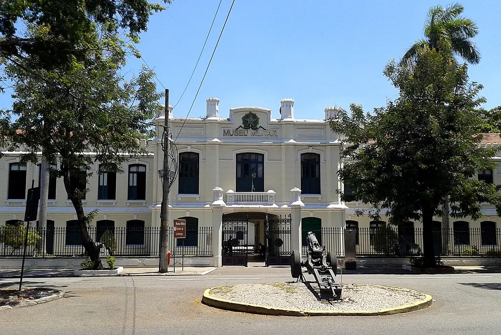 Edifício Museu Militar Conde de Linhares, dia ensolarado, céu azul, árvores, monumento com artilharia.