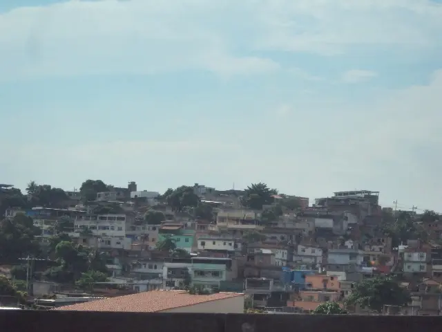 Área urbana densa com casas coloridas e edifícios azuis.