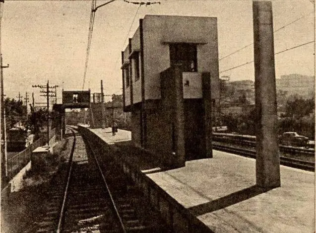 Estação ferroviária modernista em preto e branco.