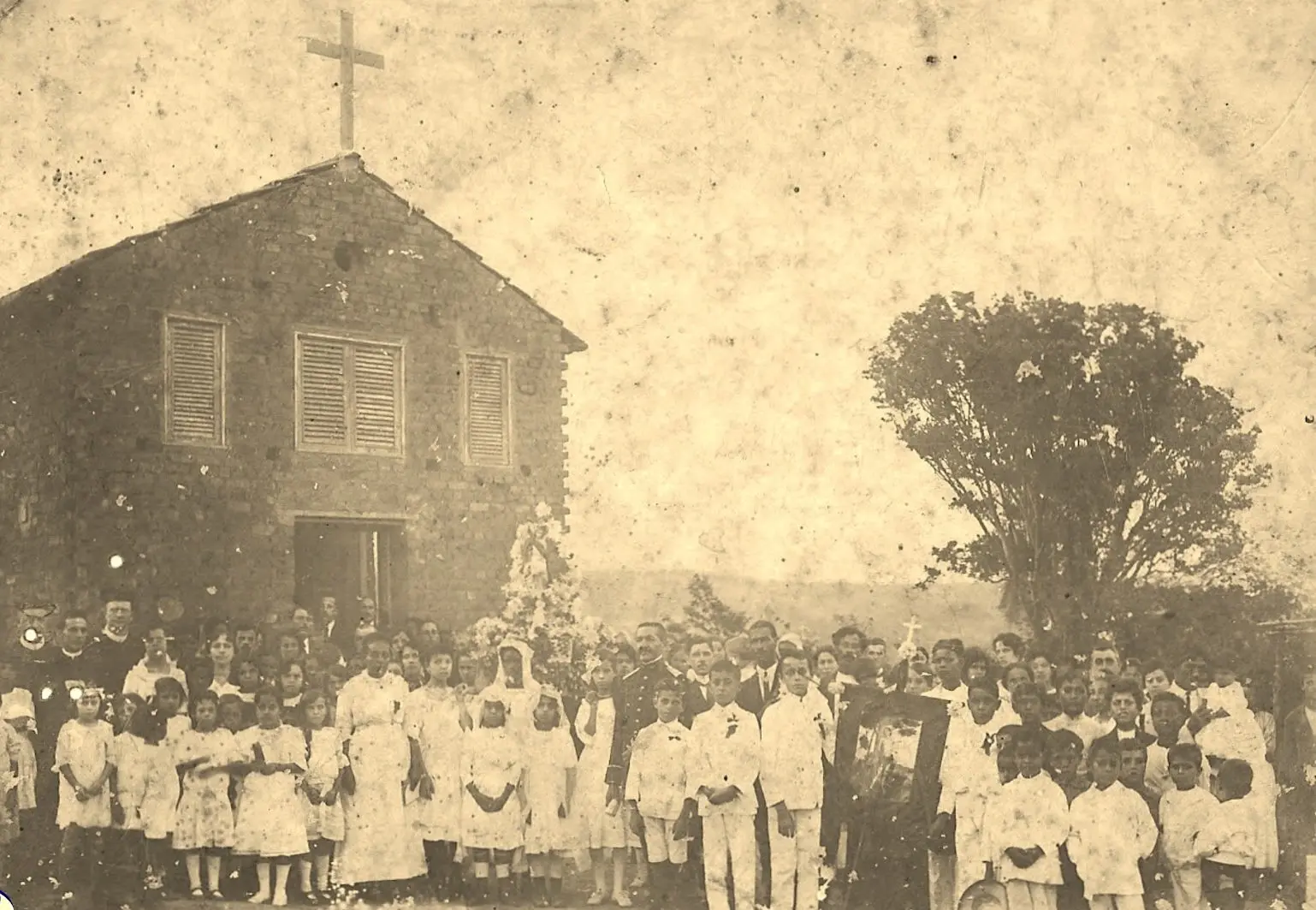 Igreja antiga com multidão em frente.