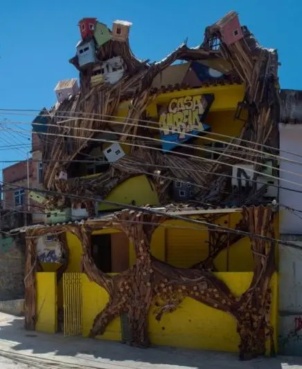 Edifício colorido com fachada vibrante e texto "CASA AMARELA".