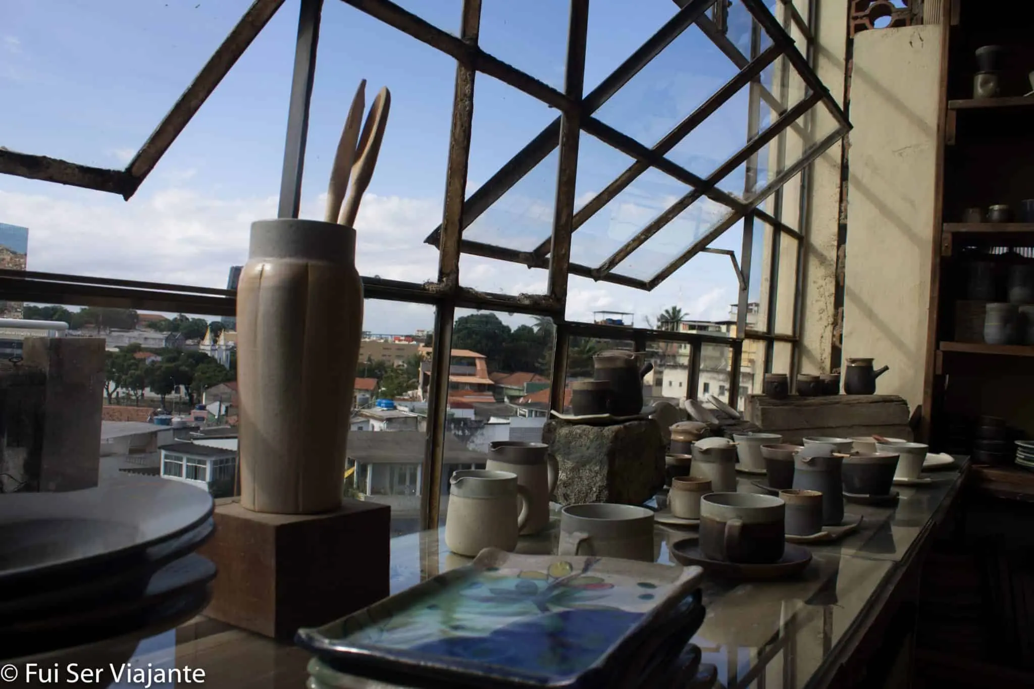 Fábrica de cerâmica com objetos e cidade ao fundo.