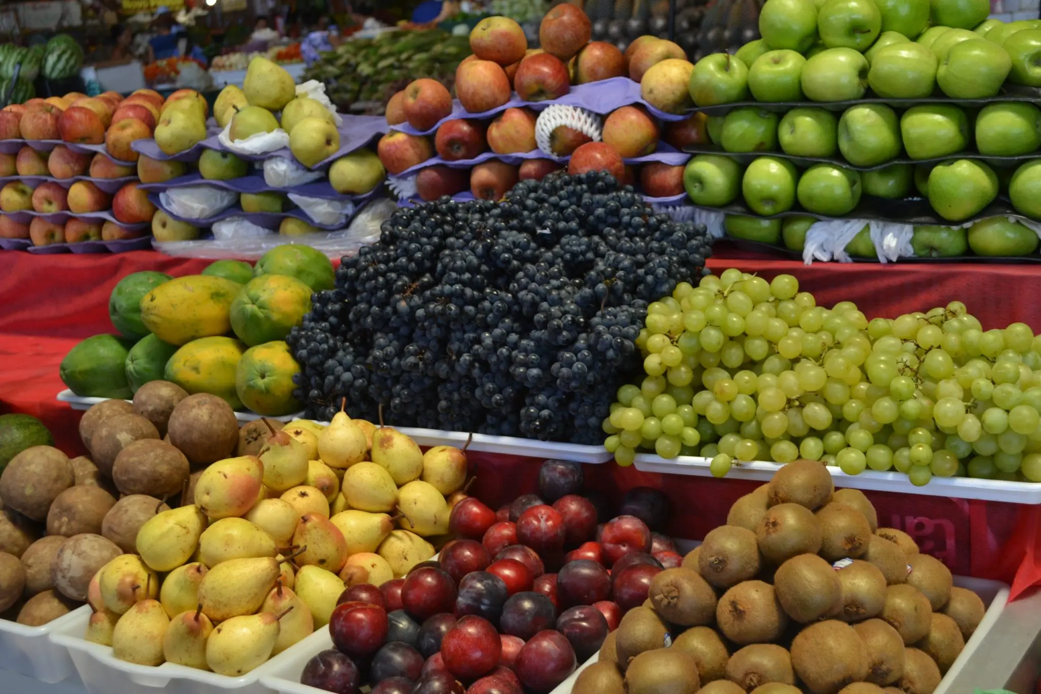 Feira livre com variedade de frutas em caixas organizadas.