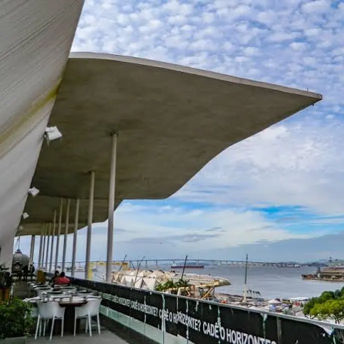 Local com vista para o mar, com estrutura moderna e marco à distância.