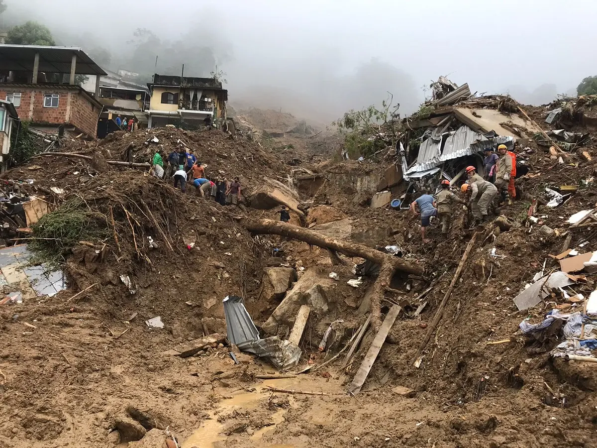 Área devastada por temporal com destroços e nevoeiro.