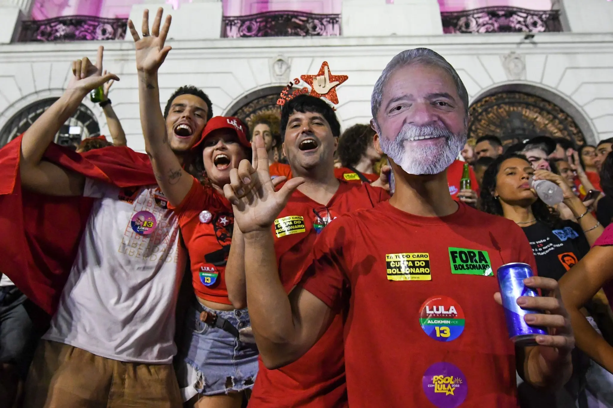 Multidão animada em frente a edifício clássico com apoio a Lula.