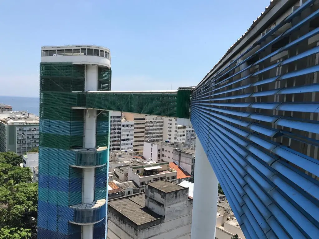 Cidade urbana com edifícios e mar ao fundo.