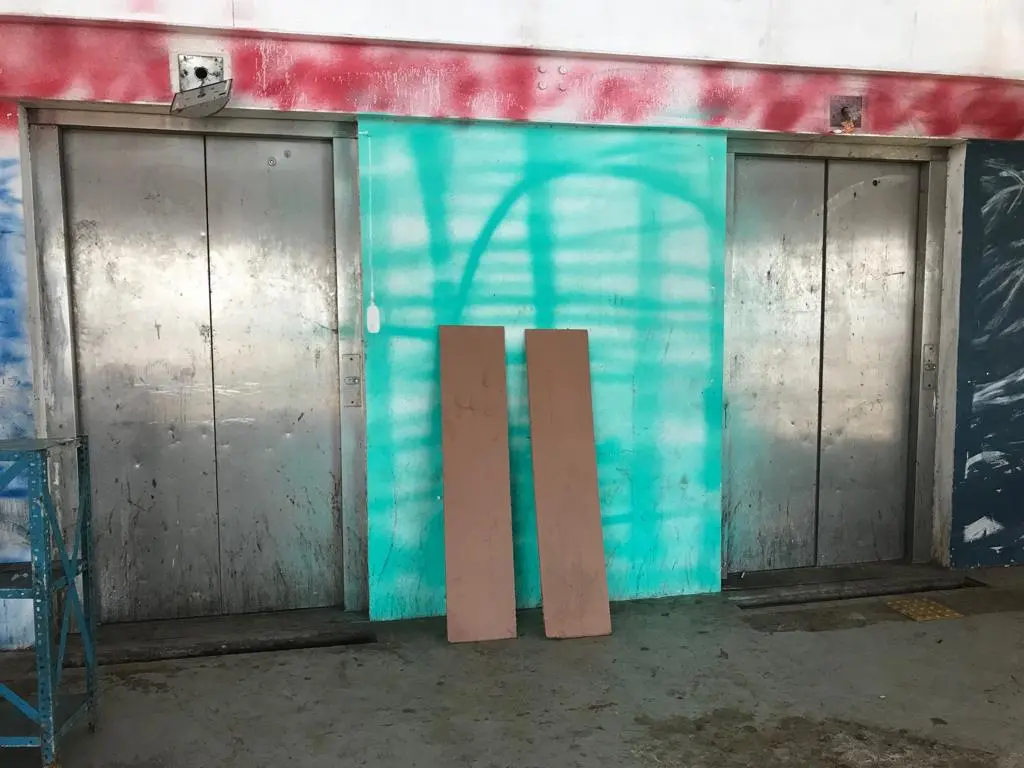 Ambiente industrial com portas metálicas e painéis de madeira.