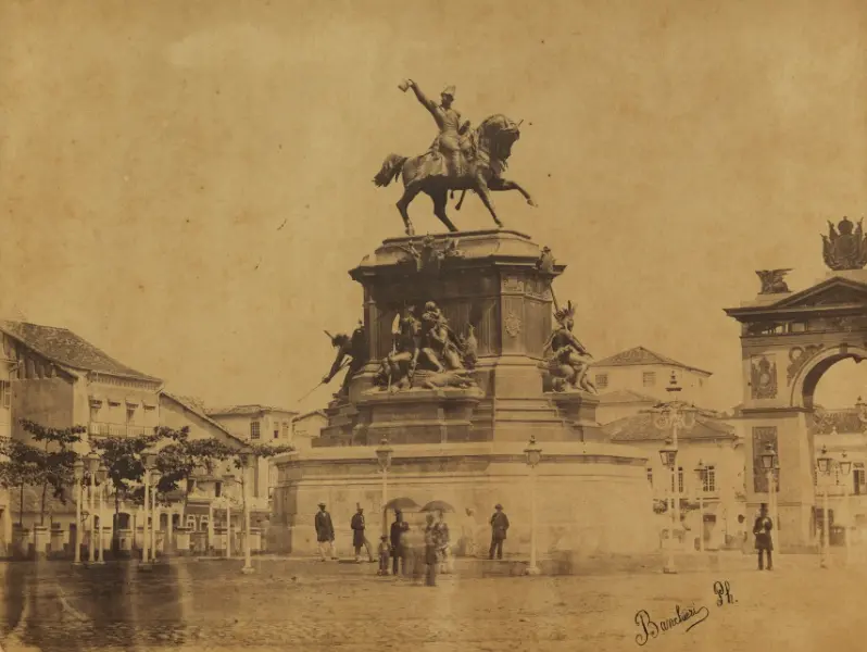 Estátua equestre em praça histórica, arquitetura monumental à direita.