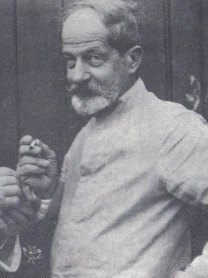 Homem idoso em preto e branco, segurando algo pequeno.