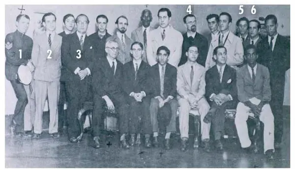 Grupo de homens em ternos clássicos em uma sala preto e branco.