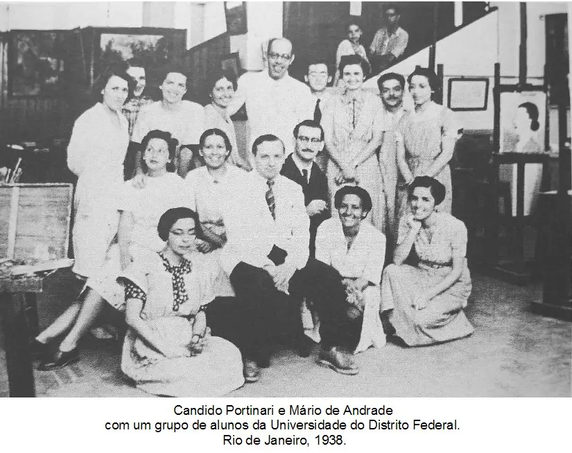 Grupo de pessoas reunidos em ambiente interno, sorrindo para a câmera.