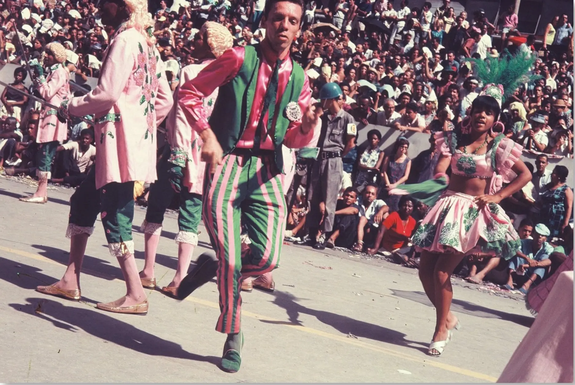 Desfile de Carnaval com dançarinos e multidão festiva.