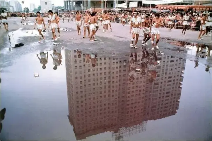 Evento público com dança tradicional em tons de bege e marrom.