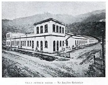 Edifício industrial antigo em preto e branco, fábrica e colina verde.